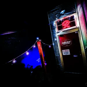 Advice Booth neon entrance glowing red and at night — Noir10 handmade LED backlit print