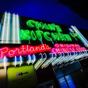Chin's Kitchen neon sign glowing green at night — Noir10 handmade LED backlit print