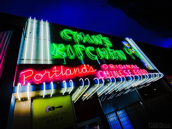 Chin's Kitchen neon sign glowing green at night — Noir10 handmade LED backlit print