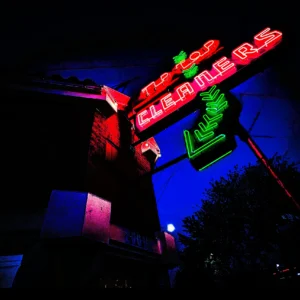 Tip Top neon sign glowing red and green at dusk — Noir10 handmade LED backlit print