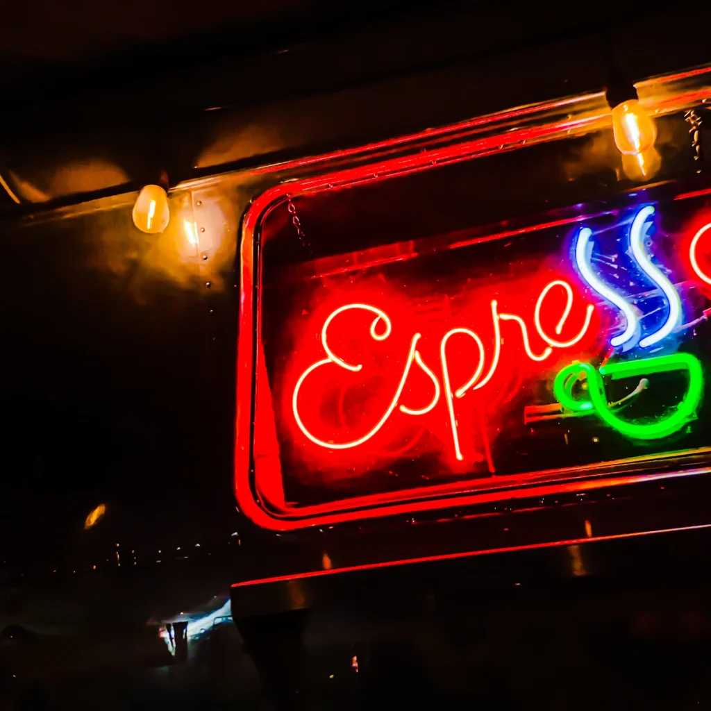 Coffee cart neon sign glowing red and green at night — Noir10 handmade LED backlit print