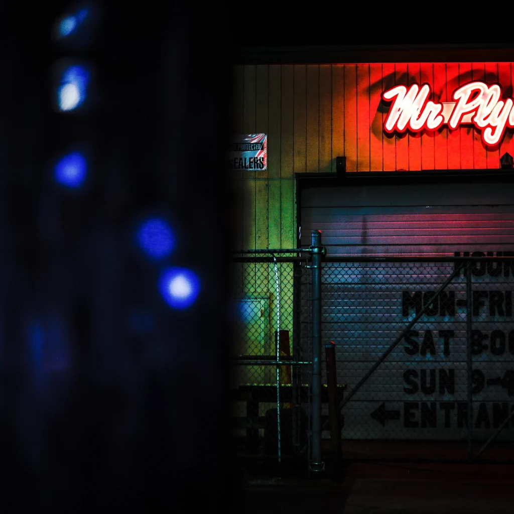 Mr. Plywood neon sign glowing red and at night — Noir10 handmade LED backlit print