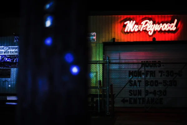 Mr. Plywood neon sign glowing red and at night — Noir10 handmade LED backlit print