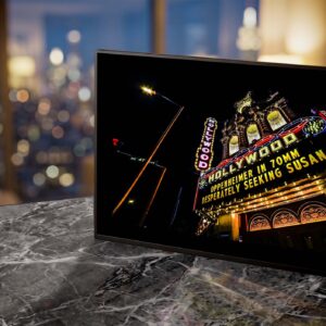 Hollywood Theater neon sign glowing yellow at night — Noir10 handmade LED backlit print
