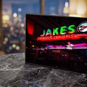Jakes Famous Crawfish neon sign glowing green at night — Noir10 handmade LED backlit print