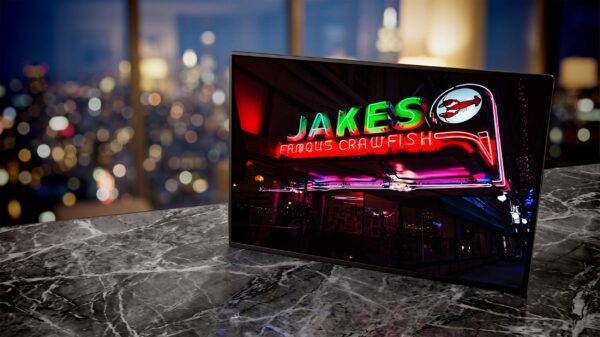 Jakes Famous Crawfish neon sign glowing green at night — Noir10 handmade LED backlit print